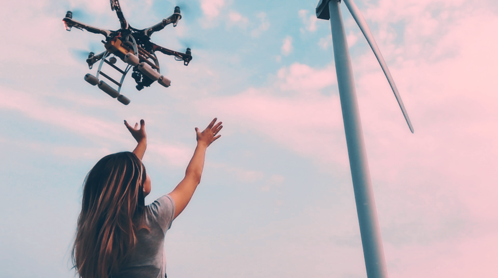 Image of a woman catching a drone coming out of the sky. 