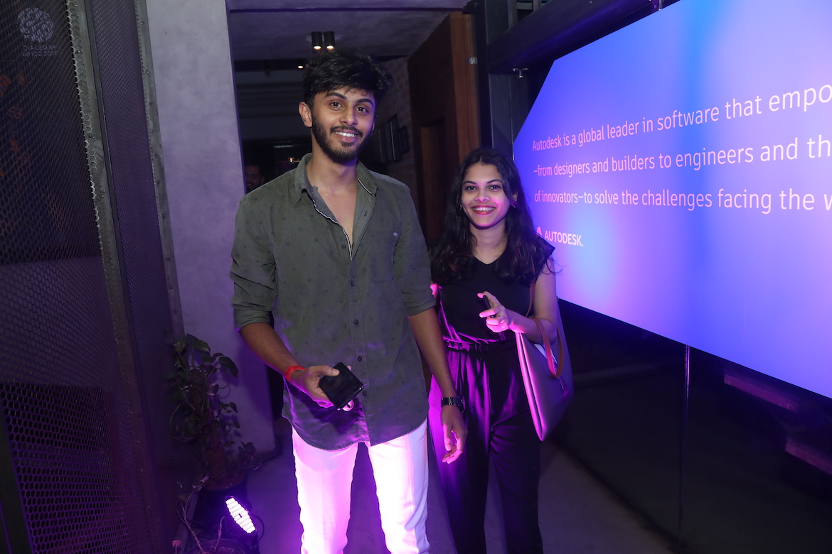 A man and woman arrive at an evening event. 