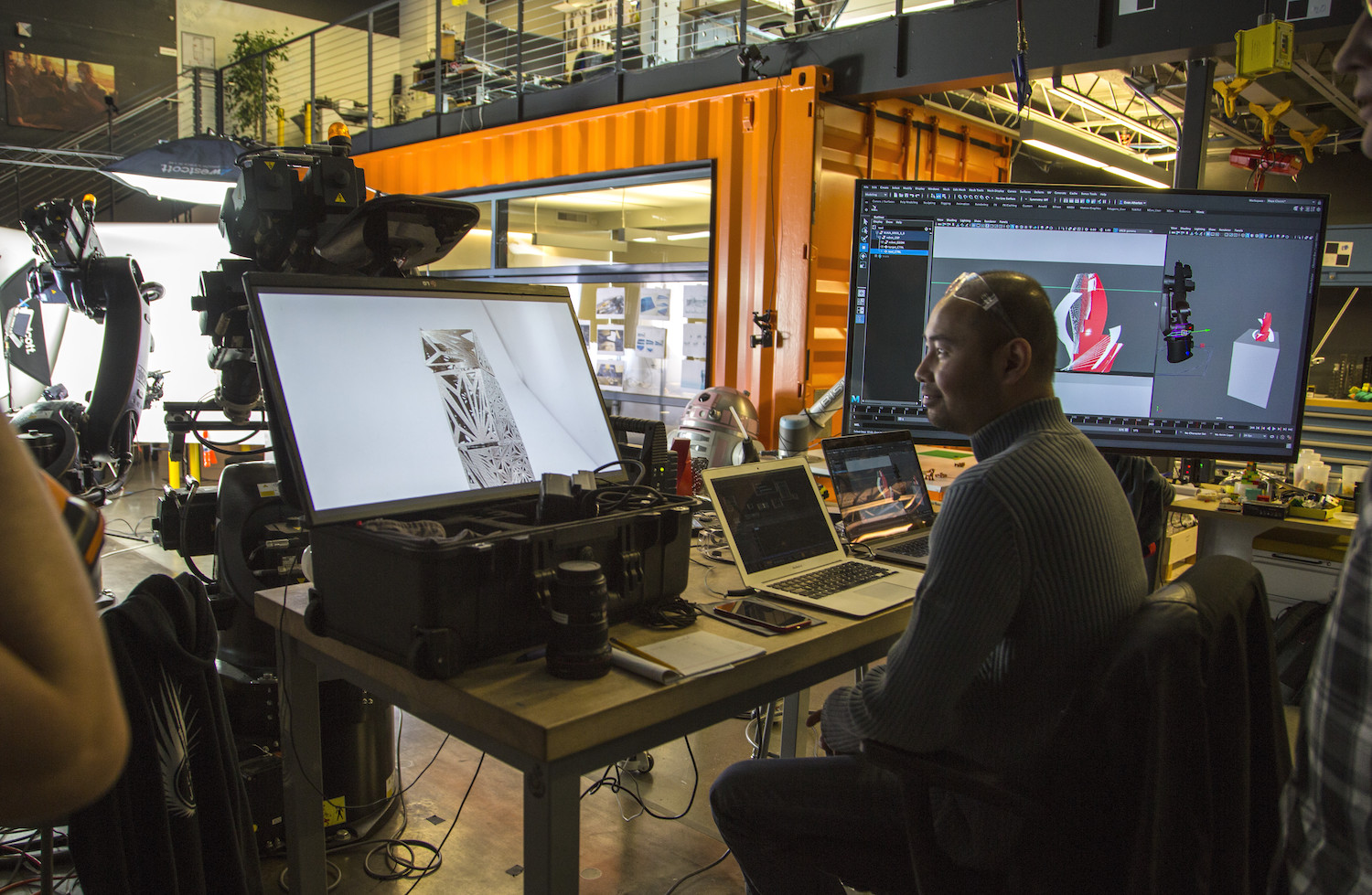 A worker at an Autodesk facility inspects a 3D model on multiple computer screens.