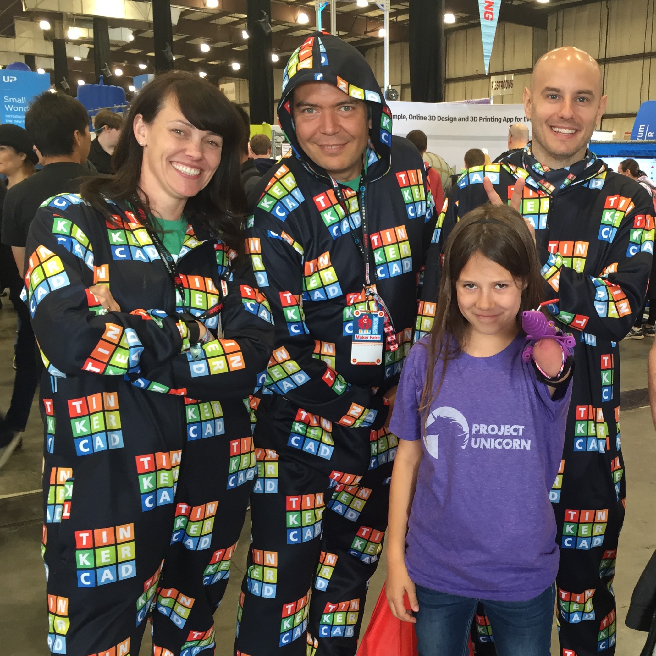 three adults and a child with a a 3D printed glitter blaster on her residual limb