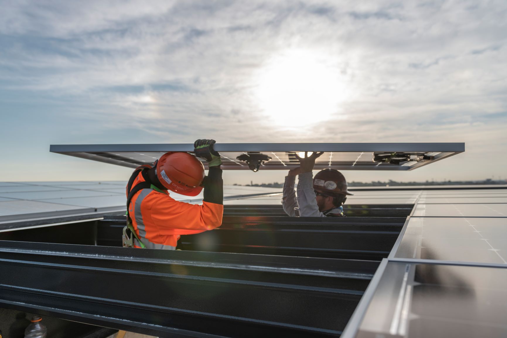 Workers installing solar panels on a building in San Antonio, TX. 