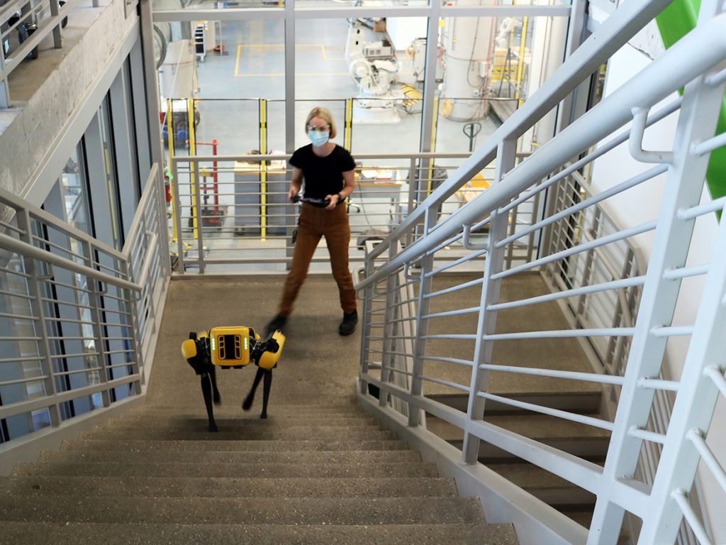 Woman with Spot robot at the Autodesk Technology Center in Boston.