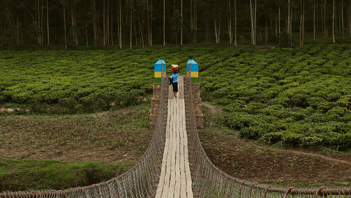 Person crossing a foot bridge in rural Uganda. 