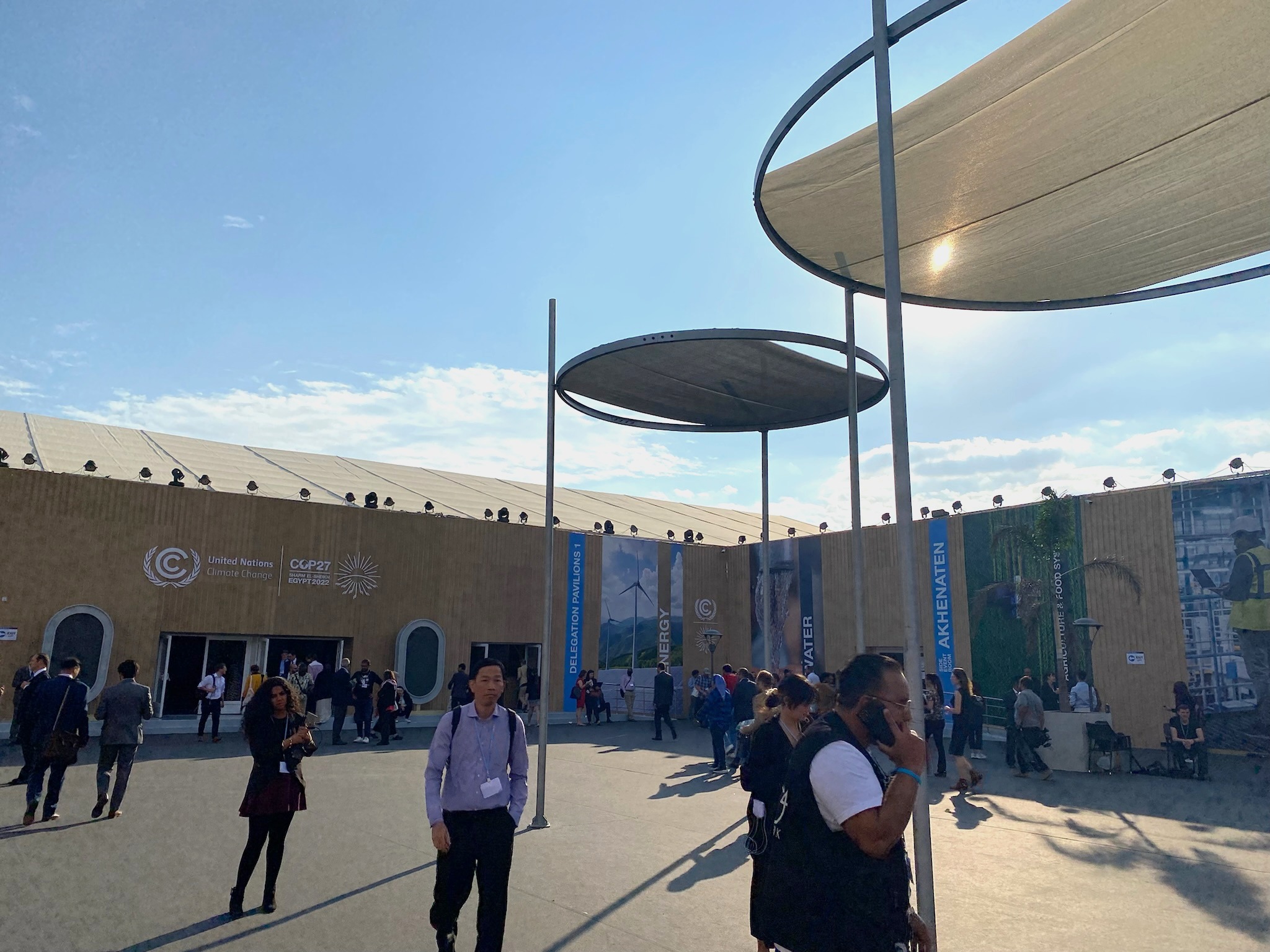 A group of people walking through an outdoor courtyard at COP27