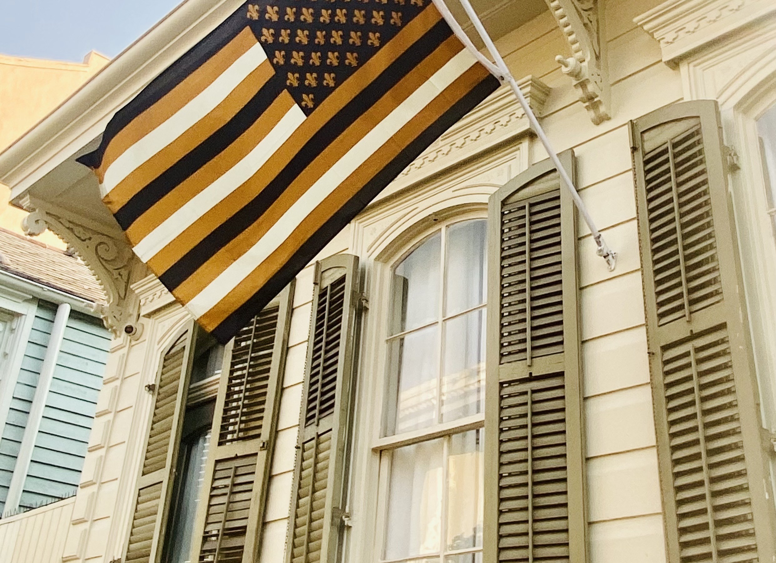 White home with green shutters and a flag