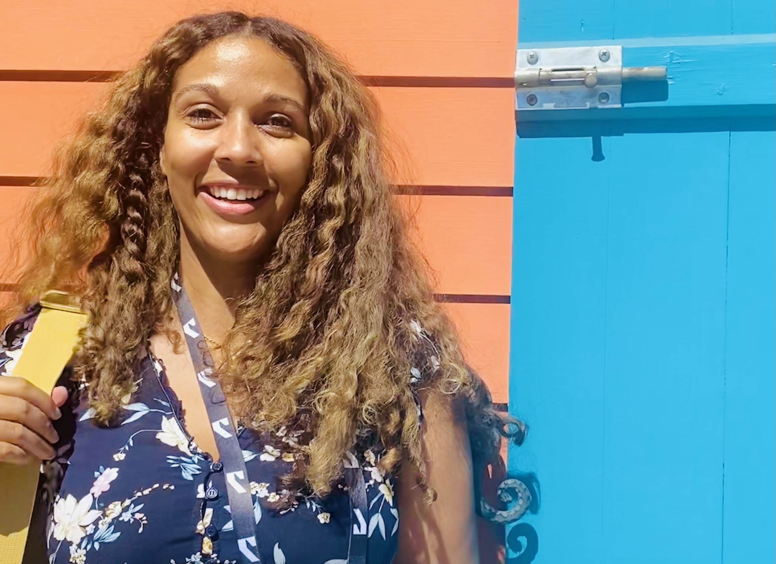 Smiling woman in front of orange and blue wall