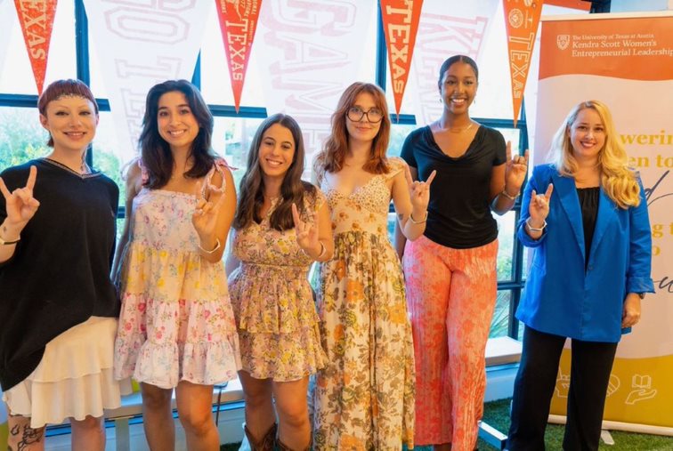 Group of jewelry design students posing in front of University of Texas signage