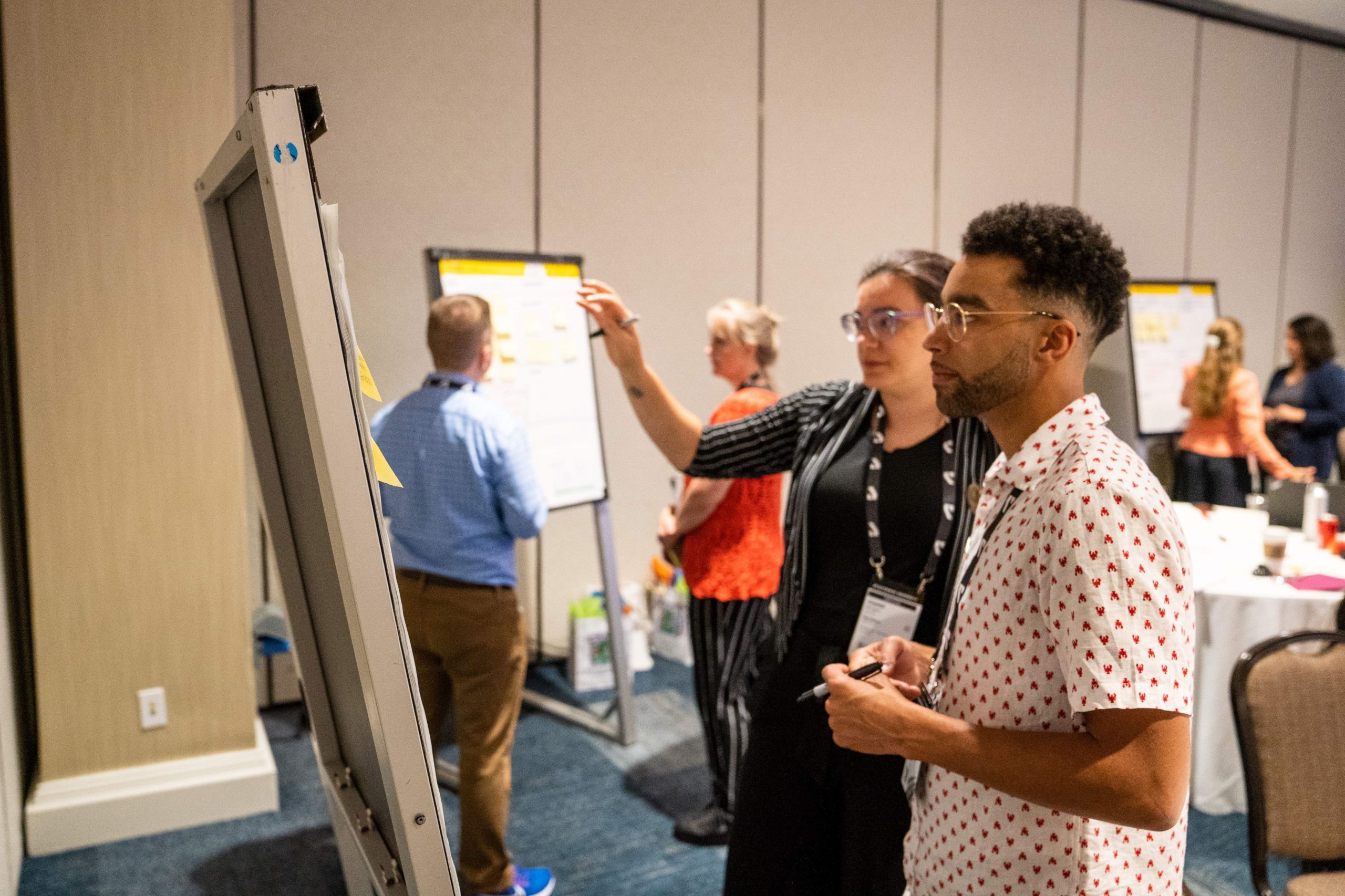 Two people standing in front of an easel paper pad