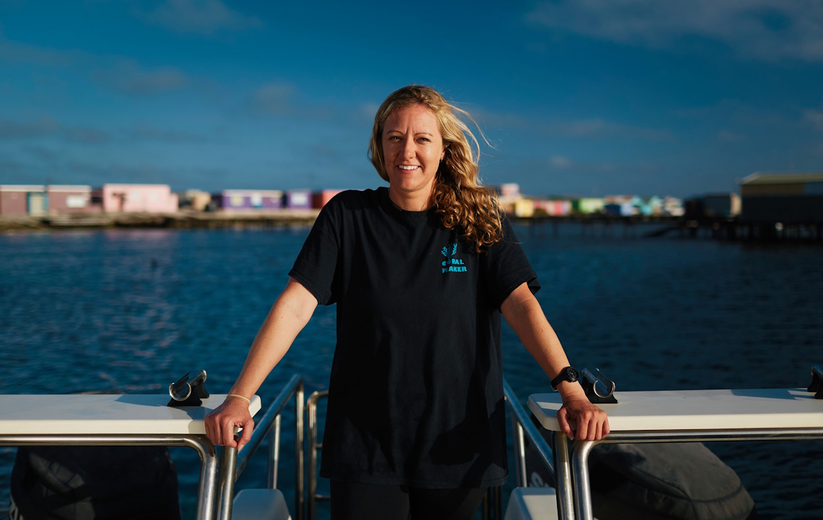 woman with blond hair standing with sea in the background