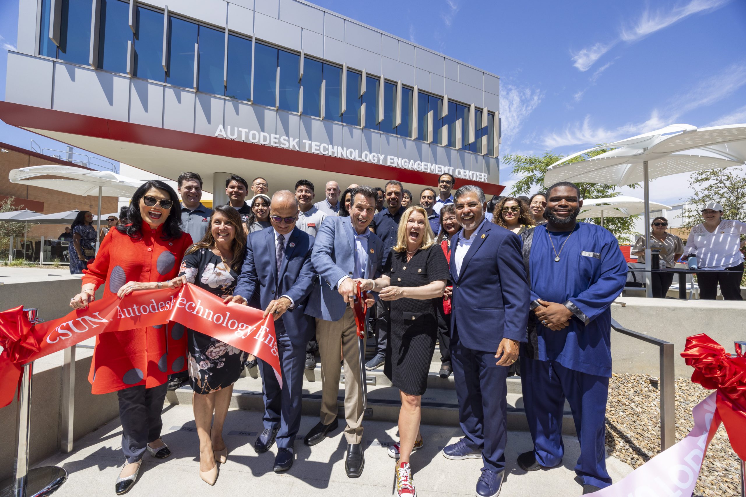 a group of executives cutting a ribbon in front of the new Autodesk Technology Engagement Center