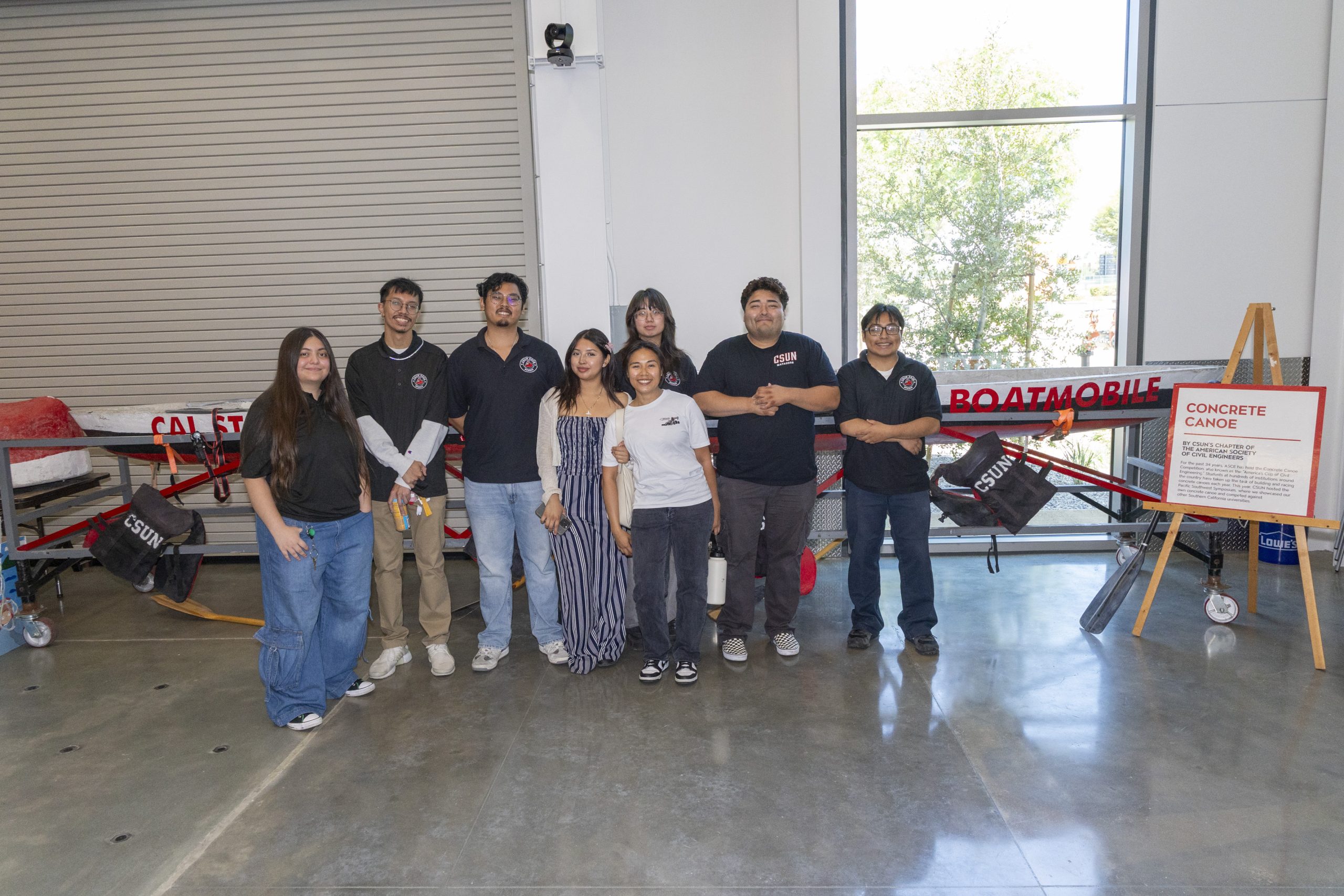 a group of students in front of a canoe in the Autodesk Technology Engagement Center