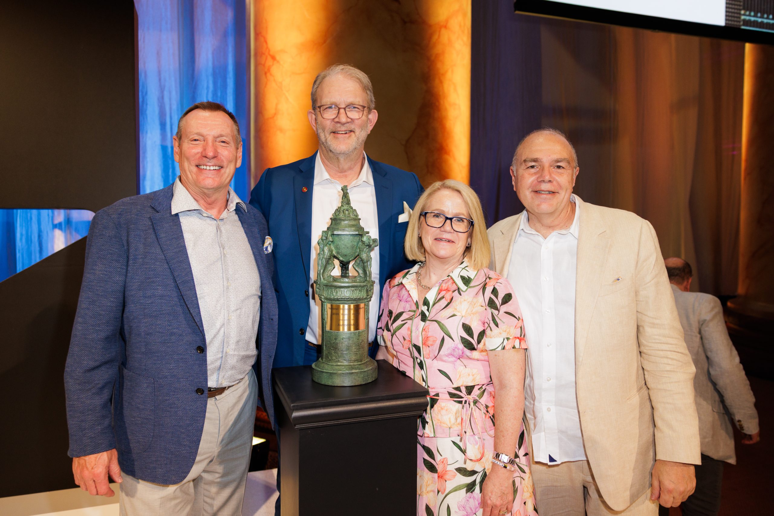 a group of people in front of a trophy